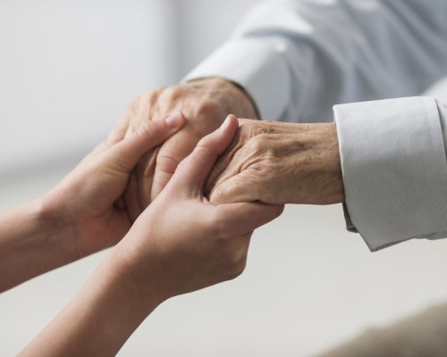 nurse-holding-senior-man-s-hands-sympathy